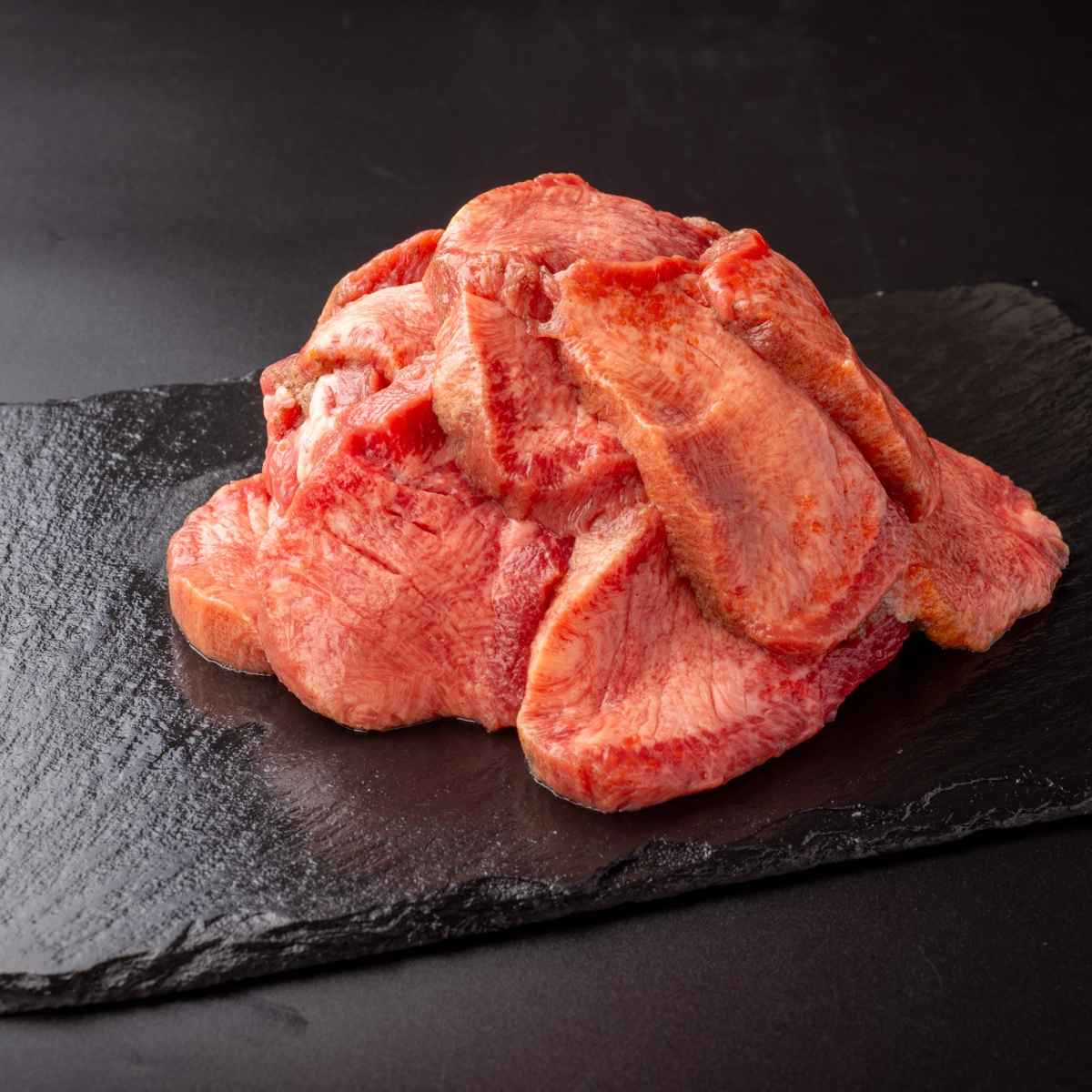 黒いお皿に盛りつけている焼く前の肉厚牛たん