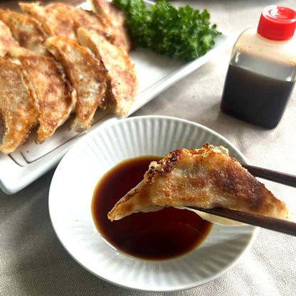 焼いてたれを付けている古都の元祖焼餃子