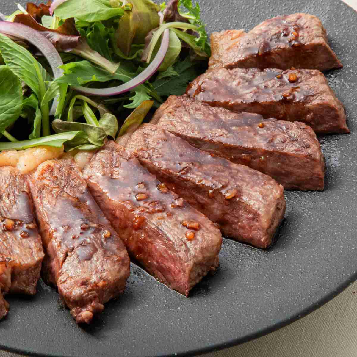 焼いてカットしてソースをかけたモッタイナイビーフの厚切りステーキ