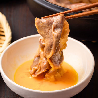 卵に絡めている 肩ロース すき焼きしゃぶしゃぶ肉